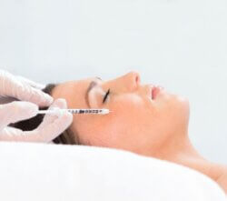 Woman getting a lip filler injection at Emma J Aesthetics