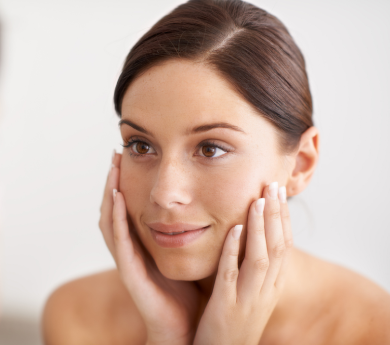 Woman with smooth and radiant skin touching her face.